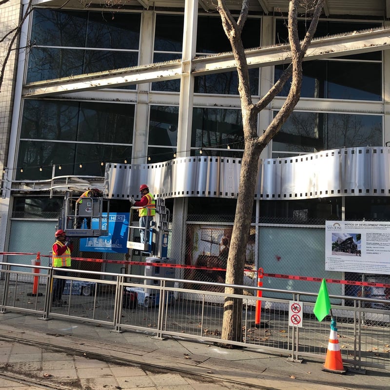 workers removing outdoor signage from building